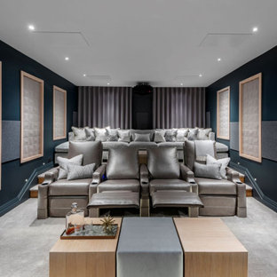 Photo of a contemporary home cinema in Other with blue walls, carpet, a projector screen and grey floors.