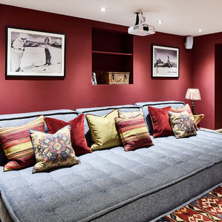 This is an example of a traditional enclosed home cinema in Cheshire with red walls and a projector screen.