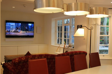 Diseño de cine en casa abierto ecléctico pequeño con paredes blancas, suelo de cemento y televisor colgado en la pared