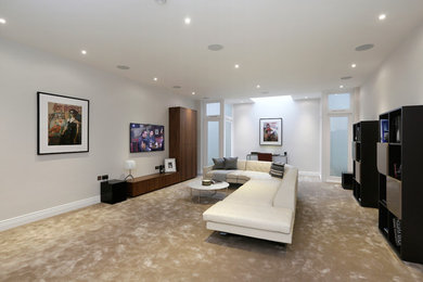 Inspiration for a contemporary home cinema in London with grey walls, carpet and a wall mounted tv.