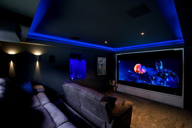 Imagen de cine en casa cerrado pequeño con paredes grises, moqueta, pantalla de proyección y suelo marrón