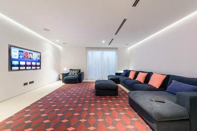 This is an example of a large modern enclosed home cinema in Other with white walls and a wall mounted tv.