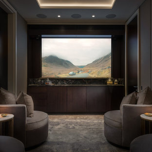 Medium sized contemporary enclosed home cinema in London with grey walls, carpet, a projector screen and grey floors.