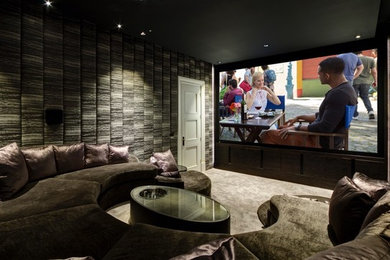 Ejemplo de cine en casa cerrado de tamaño medio con paredes grises, moqueta y pantalla de proyección