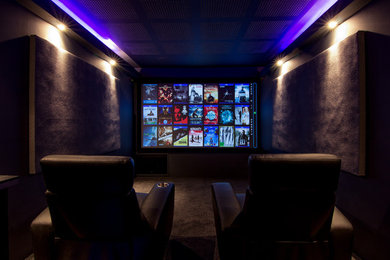 Immagine di un home theatre minimalista con pareti nere, moquette e schermo di proiezione