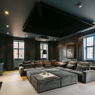 This is an example of a large contemporary home cinema in London with grey walls, carpet, a wall mounted tv and beige floors.