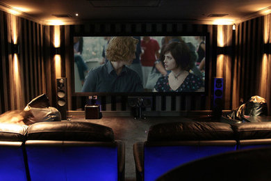 На фото: большой домашний кинотеатр в современном стиле с коричневыми стенами и ковровым покрытием