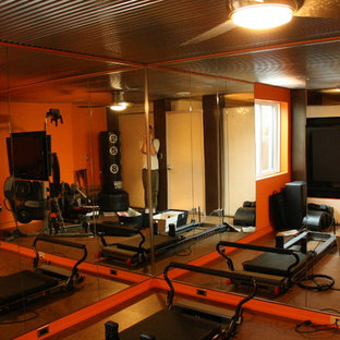 Ispirazione per una palestra in casa minimalista con pareti arancioni e pavimento in sughero