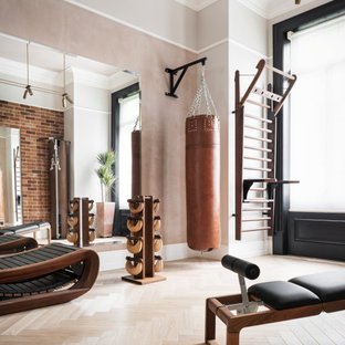 Photo of a classic home gym in London with grey walls, medium hardwood flooring and brown floors.