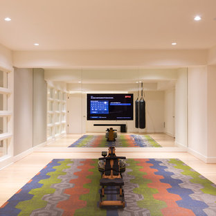 Immagine di uno studio yoga minimalista di medie dimensioni con pareti bianche e parquet chiaro