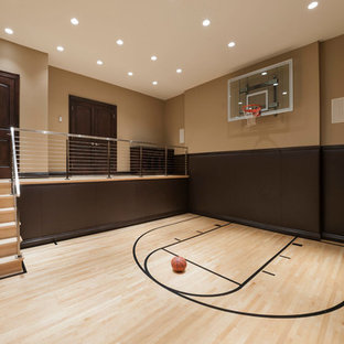 Foto di un grande campo sportivo coperto tradizionale con pareti marroni, parquet chiaro e pavimento beige