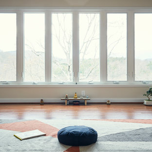 Foto di un piccolo studio yoga moderno con pareti bianche, pavimento in legno massello medio e pavimento marrone
