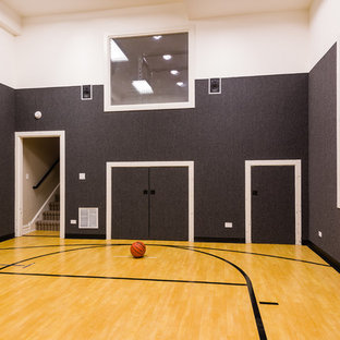 Foto di un campo sportivo coperto tradizionale di medie dimensioni con pareti grigie, parquet chiaro e pavimento marrone