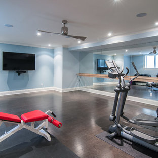 This is an example of a large traditional multipurpose gym in Other with blue walls and dark hardwood floors.