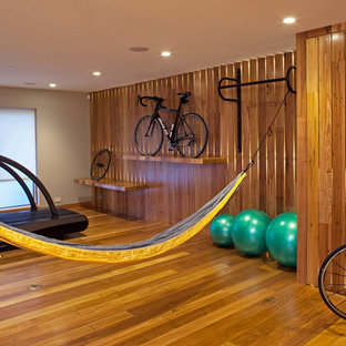 Idee per una palestra multiuso contemporanea di medie dimensioni con pavimento in legno massello medio, pareti marroni e pavimento giallo