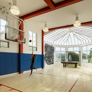 Immagine di un grande campo sportivo coperto mediterraneo con pareti bianche, parquet chiaro e pavimento beige