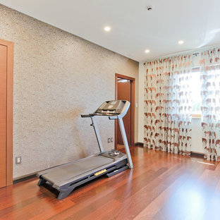 Foto di un piccolo studio yoga contemporaneo con pareti multicolore e pavimento in legno massello medio