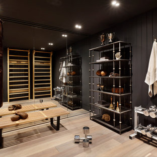 This is an example of a traditional home gym in London with grey walls, light hardwood flooring and beige floors.