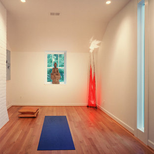 Ispirazione per uno studio yoga design con pareti bianche e pavimento arancione