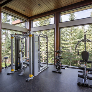 Immagine di una palestra in casa rustica con pavimento nero e soffitto in legno