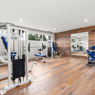 Contemporary multipurpose gym in Melbourne with white walls and dark hardwood floors.