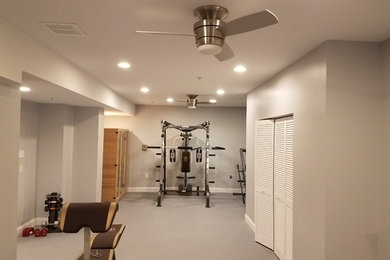 Modelo de sala de pesas tradicional grande con paredes grises, moqueta y suelo gris