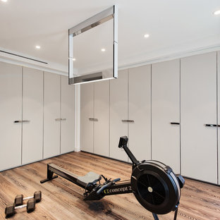 Immagine di una palestra multiuso design con pareti grigie e pavimento in legno massello medio