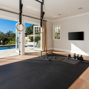 Immagine di una palestra in casa stile marino con pareti grigie e parquet chiaro