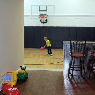 Großer Klassischer Fitnessraum mit Indoor-Sportplatz, weißer Wandfarbe und hellem Holzboden in Milwaukee