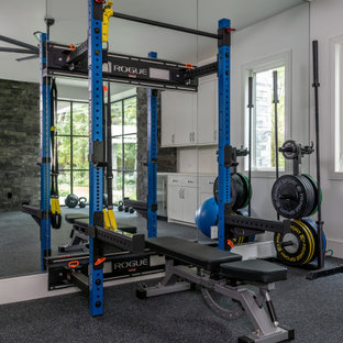Exemple d'une très grand salle de musculation tendance avec un sol noir.