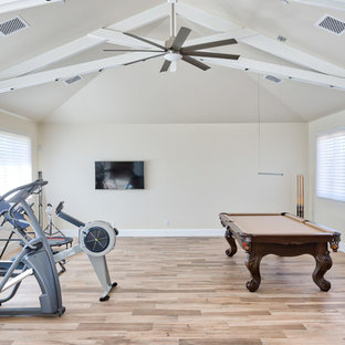 Immagine di una palestra multiuso minimal di medie dimensioni con pareti beige, pavimento in legno massello medio e pavimento beige