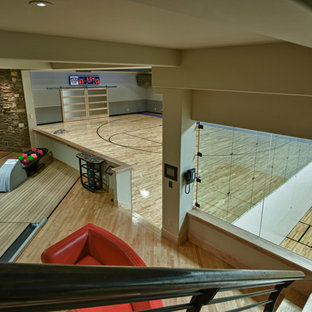Idee per un ampio campo sportivo coperto american style con pareti beige e parquet chiaro