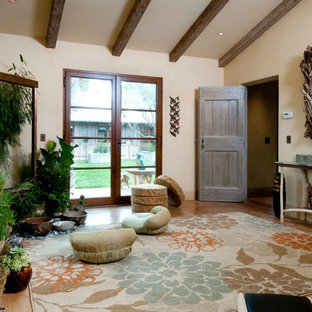 Esempio di un grande studio yoga mediterraneo con pareti beige, pavimento in travertino e pavimento marrone