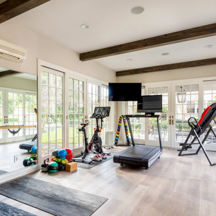 Foto di una palestra multiuso con pareti beige, parquet chiaro, pavimento beige e travi a vista