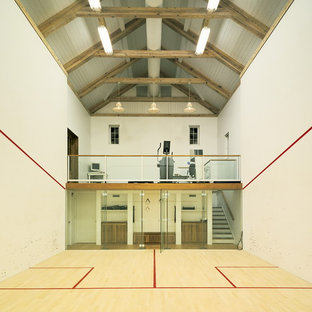 Esempio di un grande campo sportivo coperto country con pareti bianche e parquet chiaro