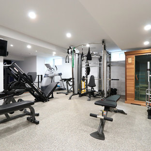 Immagine di una grande sala pesi moderna con pareti bianche e pavimento grigio