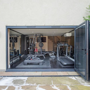Ispirazione per una palestra multiuso minimal di medie dimensioni con pareti beige, parquet scuro e pavimento nero