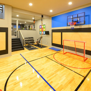 Großer Klassischer Fitnessraum mit Indoor-Sportplatz, grauer Wandfarbe, hellem Holzboden und gelbem Boden in Calgary
