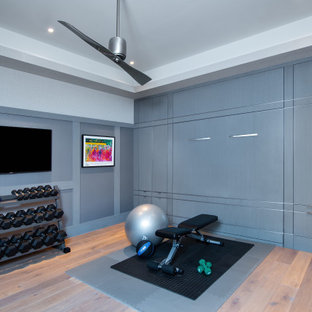 Immagine di una palestra in casa mediterranea con pavimento in legno massello medio e soffitto ribassato