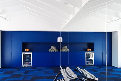 Ejemplo de gimnasio multiusos contemporáneo grande con paredes azules, moqueta y suelo azul