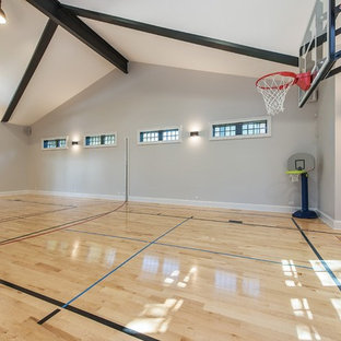 Esempio di un ampio campo sportivo coperto country con pareti grigie e parquet chiaro
