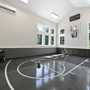 Immagine di un campo sportivo coperto tradizionale con pareti grigie, parquet scuro e pavimento grigio