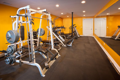 Home weight room - large contemporary black floor home weight room idea in New York with yellow walls
