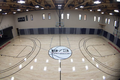 Large classic indoor sports court in Phoenix with beige walls and light hardwood flooring.