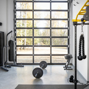 Moderner Fitnessraum mit weißer Wandfarbe, Betonboden und grauem Boden in Edmonton
