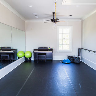 Foto di una grande palestra multiuso classica con pareti beige, pavimento in legno verniciato e pavimento nero