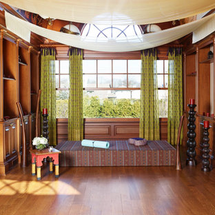 Immagine di uno studio yoga di medie dimensioni con pareti beige, parquet scuro, pavimento marrone e soffitto a volta
