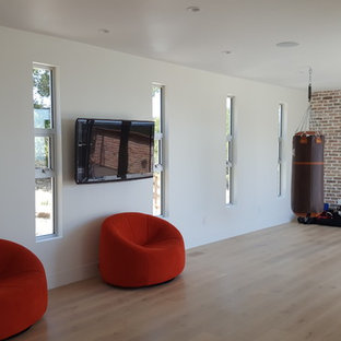 Immagine di una grande palestra multiuso moderna con pareti bianche, parquet chiaro e pavimento beige