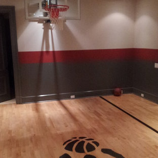 Foto di un campo sportivo coperto moderno di medie dimensioni con pareti multicolore e parquet chiaro