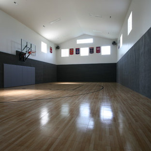 Ispirazione per un grande campo sportivo coperto tradizionale con pareti nere e parquet chiaro